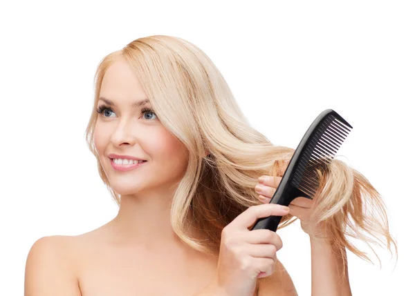 Femme souriante avec brosse à cheveux — Photo