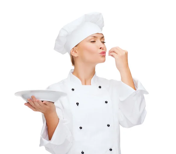 Lezzetli işaret gösteren plaka ile kadın aşçı — Stok fotoğraf