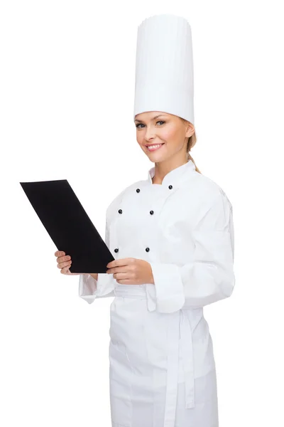 Chef feminino sorridente com papel em branco preto — Fotografia de Stock