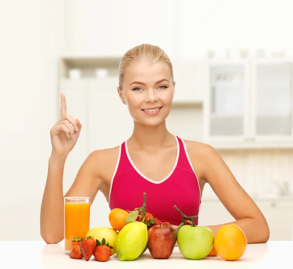 Mulher com suco e frutas segurando o dedo para cima — Fotografia de Stock