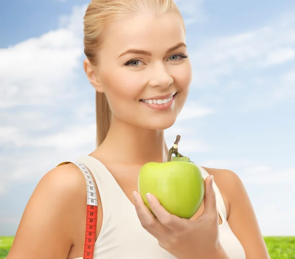 Deportiva mujer con manzana y cinta métrica —  Fotos de Stock