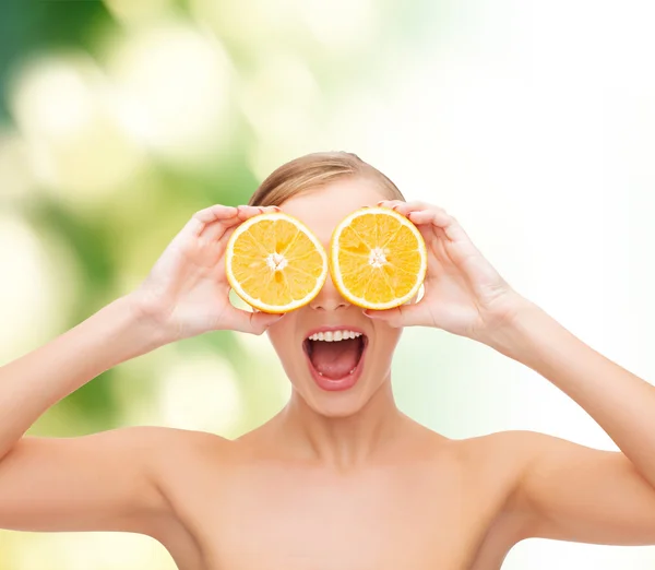 Mujer joven asombrada con rodajas de naranja — Foto de Stock