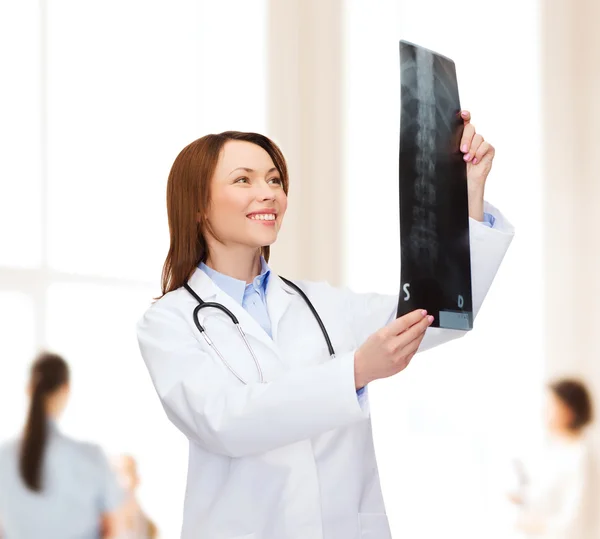 Gülümseyen kadın doktor röntgene bakıyor. — Stok fotoğraf