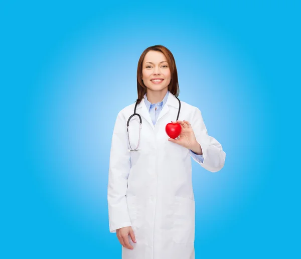 Glimlachende vrouwelijke arts met hart en stethoscoop — Stockfoto