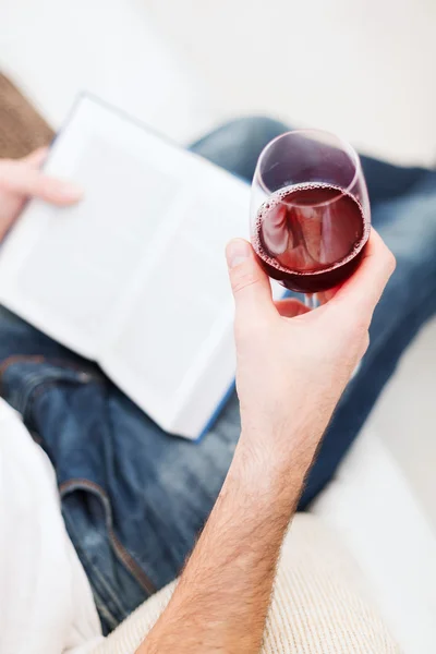 Mannenhand holdind boek en glas rode wijn — Stockfoto