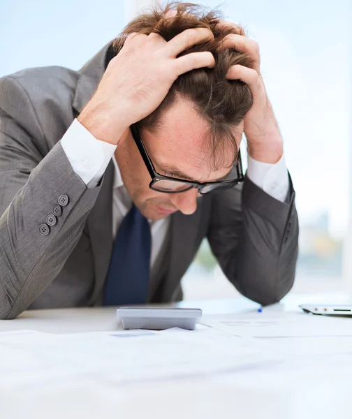 Uomo d'affari con papres, laptop e calcolatrice — Foto Stock