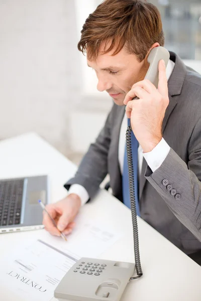 Empresário com computador portátil e telefone — Fotografia de Stock