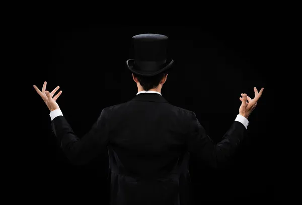 Magician in top hat showing trick from the back — Stock Photo, Image