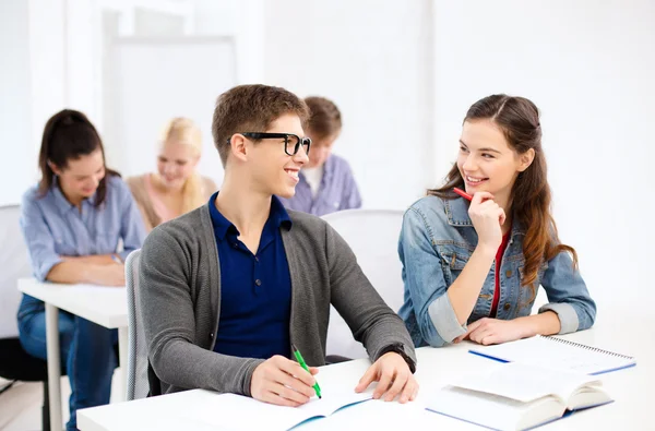 Lachende studenten met laptops op school — Stockfoto