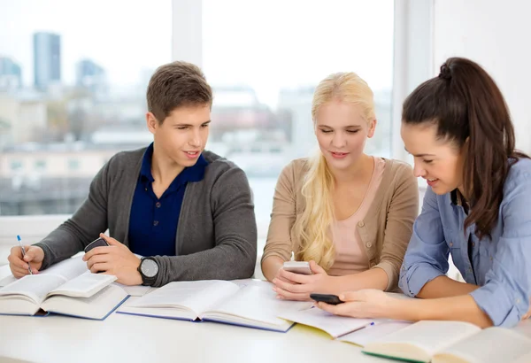 Lächelnde Schüler mit Notizbüchern in der Schule — Stockfoto