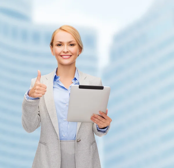 Smiling woman with tablet pc showing thumbs up — Stock Photo, Image