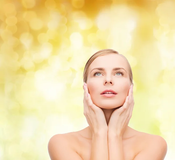 Beautiful woman touching her face and looking up — Stock Photo, Image