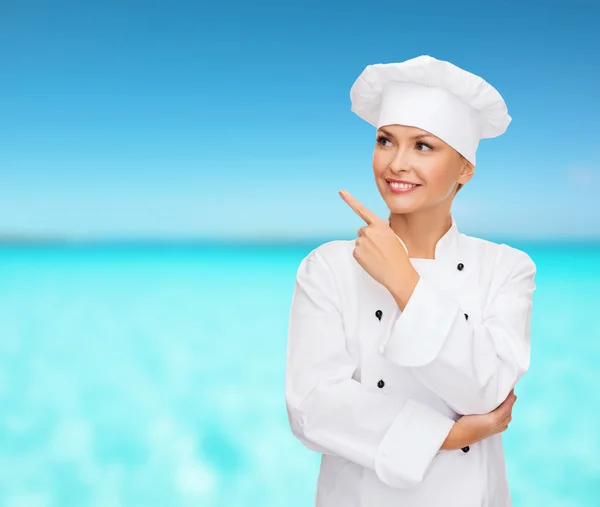 Улыбающаяся женщина-шеф-повар указывает пальцем на сонетование — стоковое фото