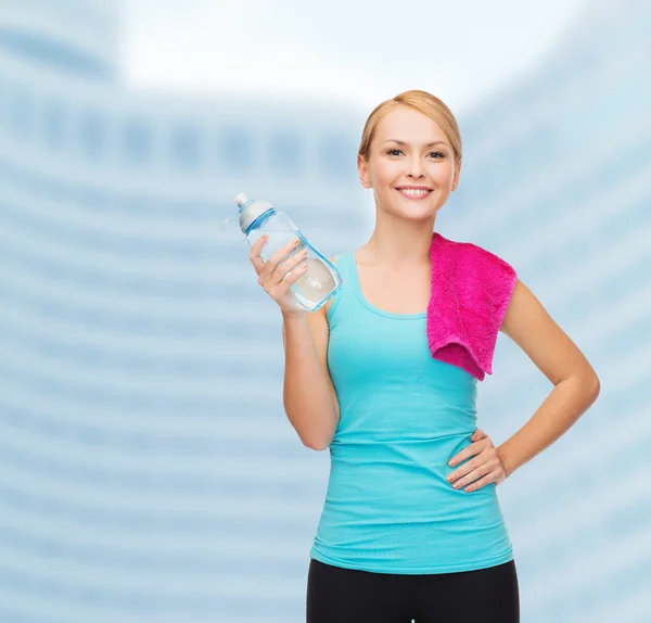 Спортивная женщина с полотенцем и бутылкой ватела — стоковое фото