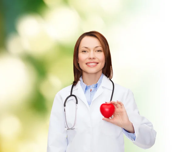 Doctora sonriente con corazón y estetoscopio — Foto de Stock