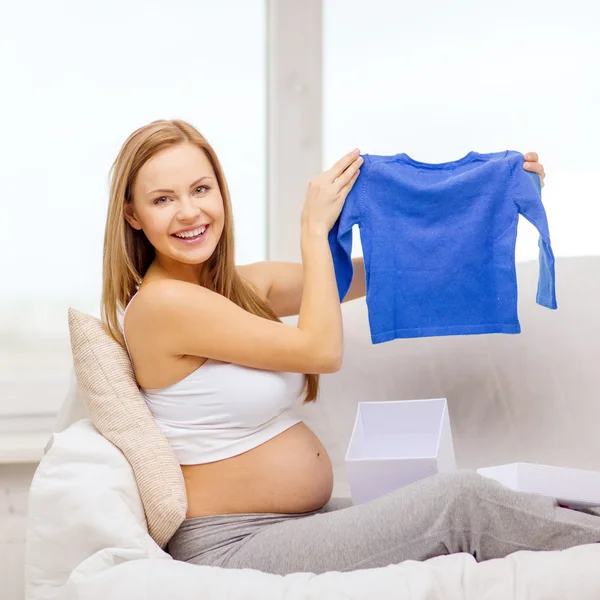 Улыбающаяся беременная открывает подарочную коробку — стоковое фото
