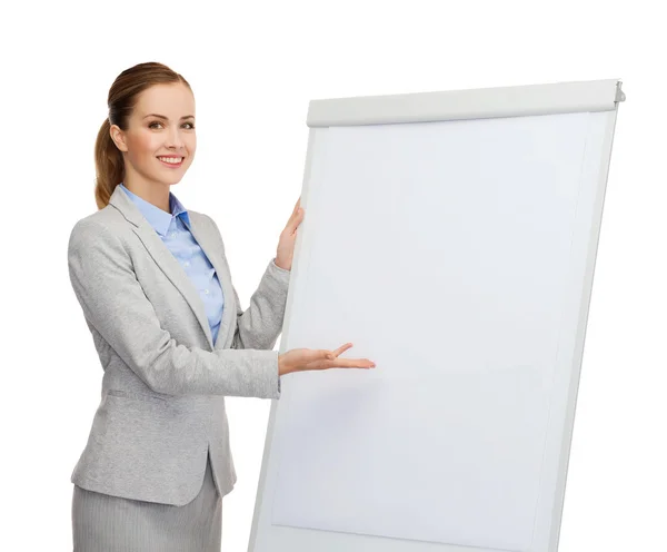 Smiling businesswoman standing next to flipboard — Stock Photo, Image