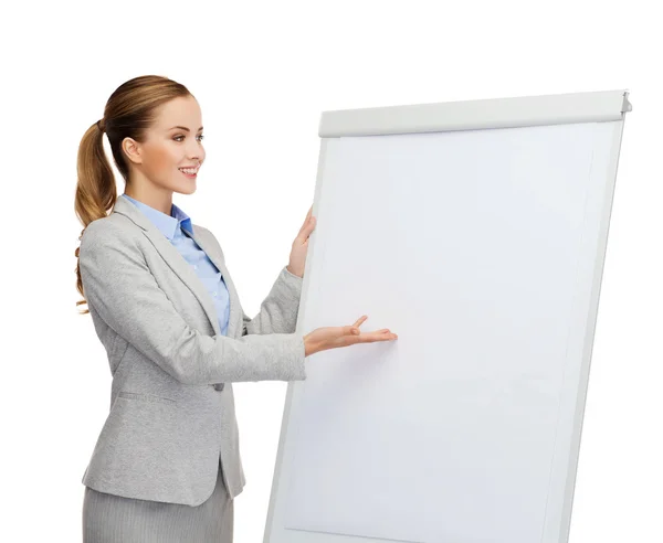 Smiling businesswoman standing next to flipboard — Stock Photo, Image