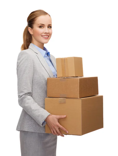 Smiling businesswoman holding cardboard boxes — Stock Photo, Image