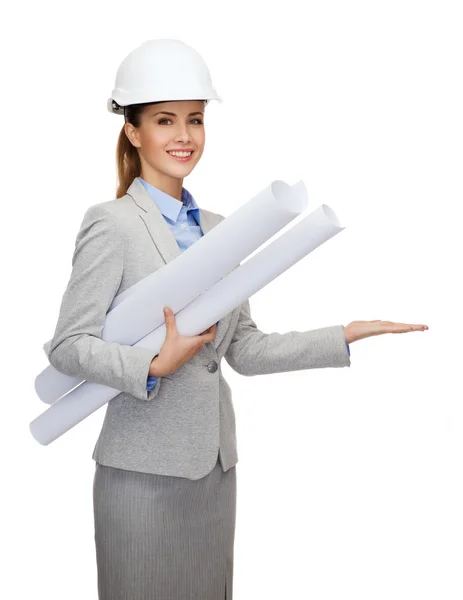 Lächelnder Architekt mit weißem Helm und Blaupausen — Stockfoto