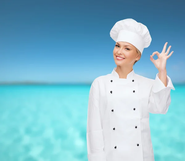 Glimlachend vrouwelijke chef-kok weergegeven: ok hand teken — Stockfoto