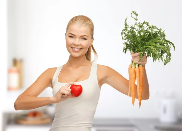 Женщина с символом сердца и морковью — стоковое фото