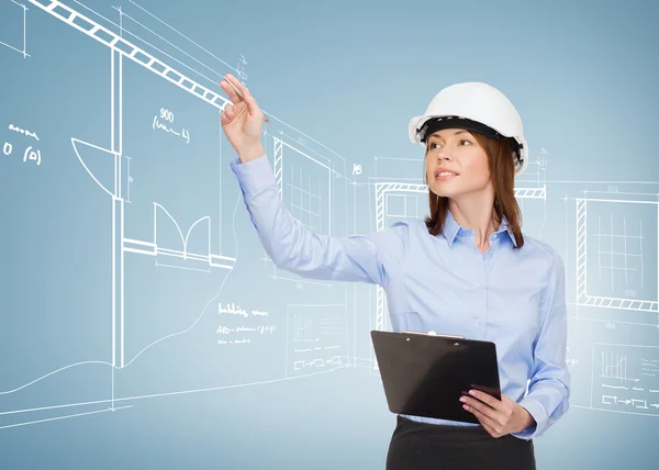 Smiling businesswoman in helmet with clipboard — Stock Photo, Image