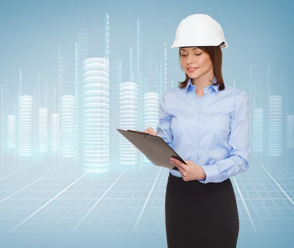 Smiling businesswoman in helmet with clipboard — Stock Photo, Image