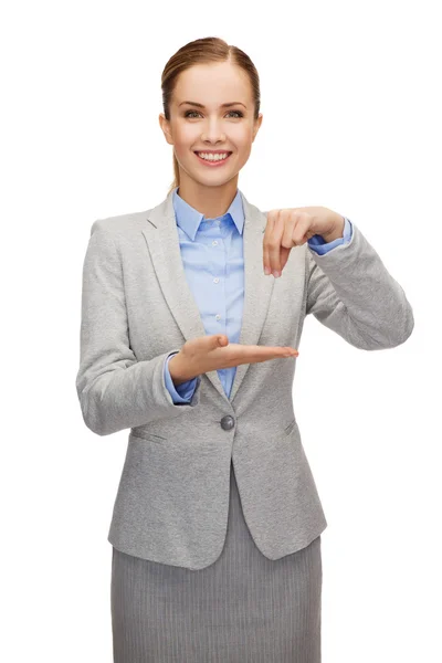 Smiling businesswoman holding something imaginary — Stock Photo, Image