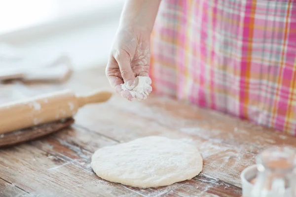 生地に小麦粉を振りかける女性の手のクローズ アップ — ストック写真