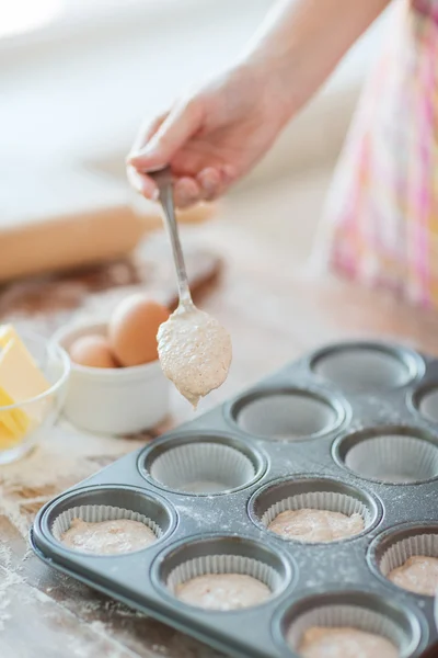 Close up de moldes de muffins de enchimento de mão com massa — Fotografia de Stock