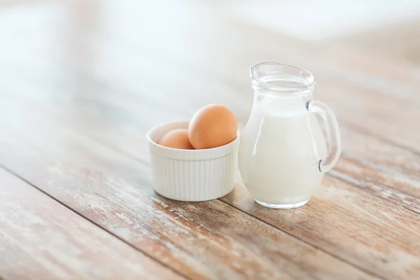 Närbild på jugful av mjölk och ägg i en skål — Stockfoto