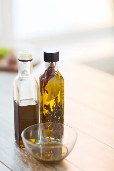 Nærbillede af to olivenolieflasker og skål olie - Stock-foto