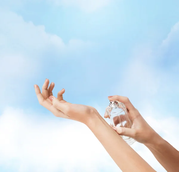 Mujer manos rociando perfume — Foto de Stock