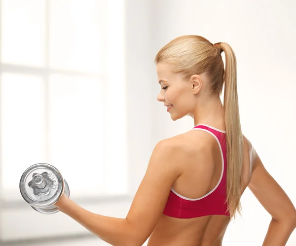 Smiling woman with heavy steel dumbbell — Stock Photo, Image