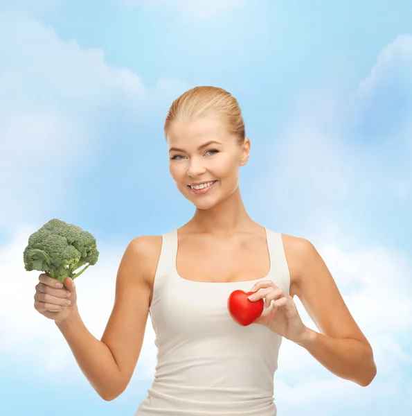 Leende kvinna med hjärtsymbol och broccoli — Stockfoto