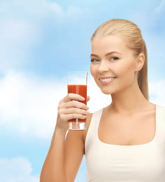 Leende kvinna anläggning glas tomatjuice — Stockfoto