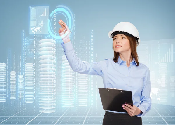 Mujer de negocios sonriente en casco con portapapeles — Foto de Stock