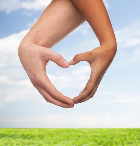 Manos de hombre y mujer mostrando forma de corazón — Foto de Stock