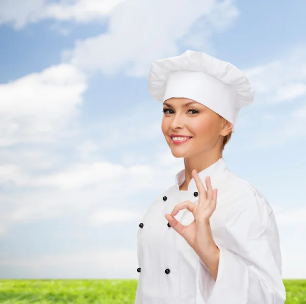 Glimlachend vrouwelijke chef-kok weergegeven: ok hand teken — Stockfoto