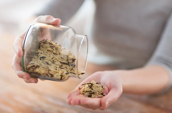 Női ürítés jar, fehér és a vadon élő fekete rizs — Stock Fotó