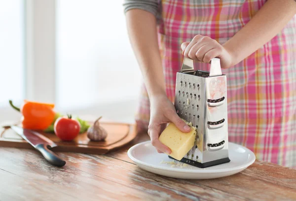 Close up of female hands grating cheese — Stock Photo, Image