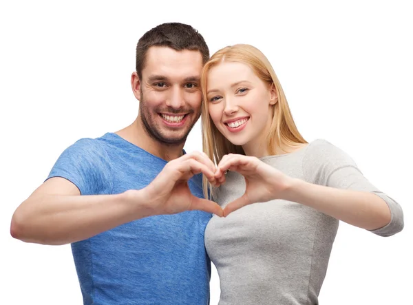 Smiling couple showing heart with hands — Stok fotoğraf