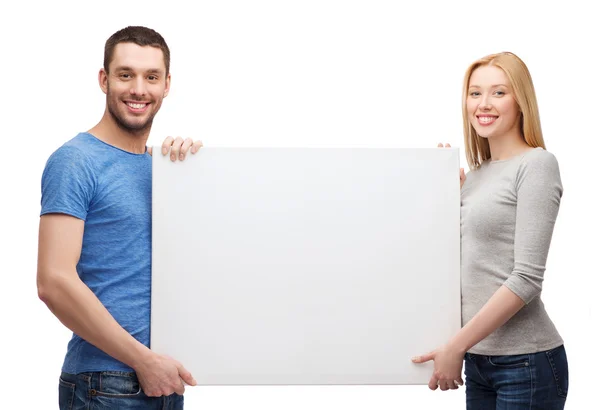 Sorrindo casal segurando placa branca em branco — Fotografia de Stock