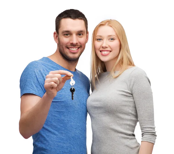 Smiling couple holding keys — Stock Photo, Image