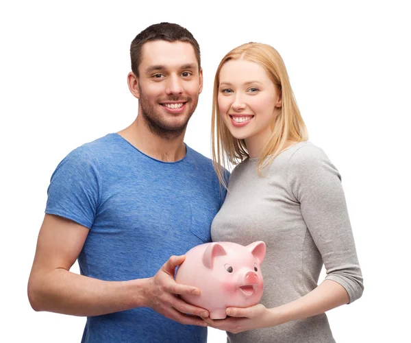 Sorrindo casal segurando grande porquinho banco — Fotografia de Stock