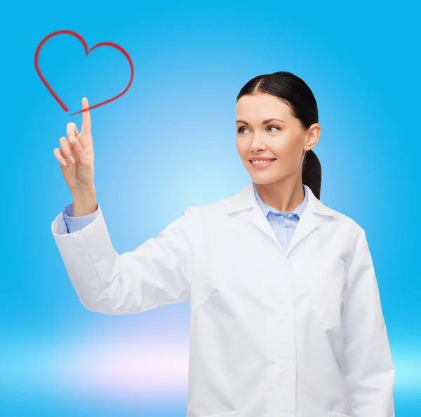 Doctora sonriente señalando al corazón — Foto de Stock