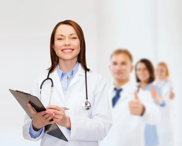 Médica sorridente com prancheta — Fotografia de Stock