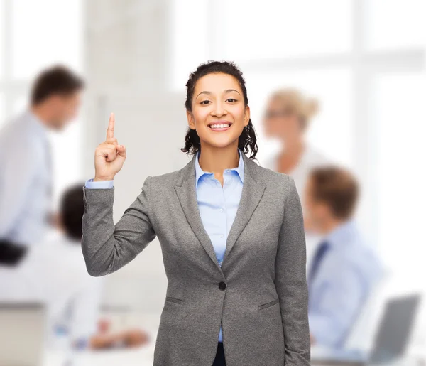 Uśmiechający się kobieta z jej palec w górę w urzędzie — Zdjęcie stockowe