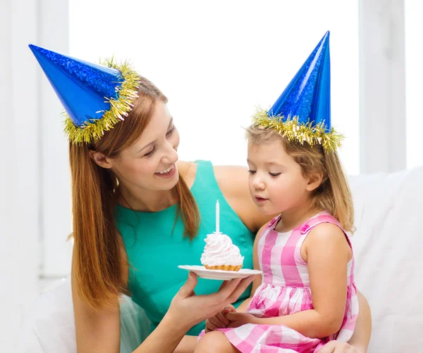 Madre e hija en sombreros azules con pastel — Foto de Stock